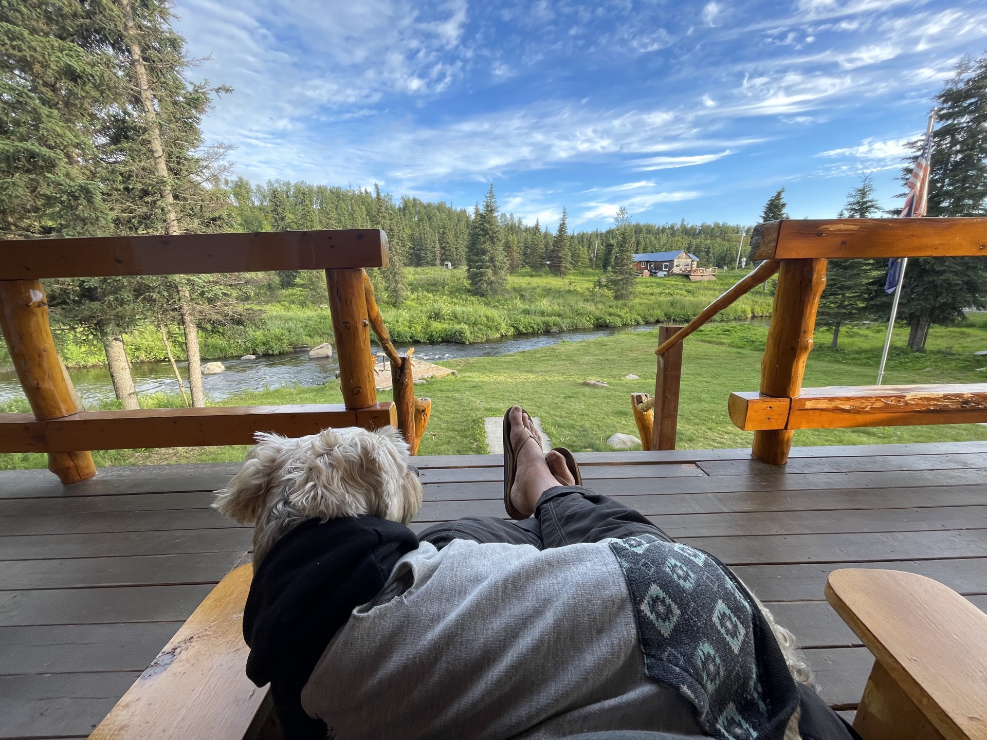 The Riverview deck — feet up, dog at your knee, river in front